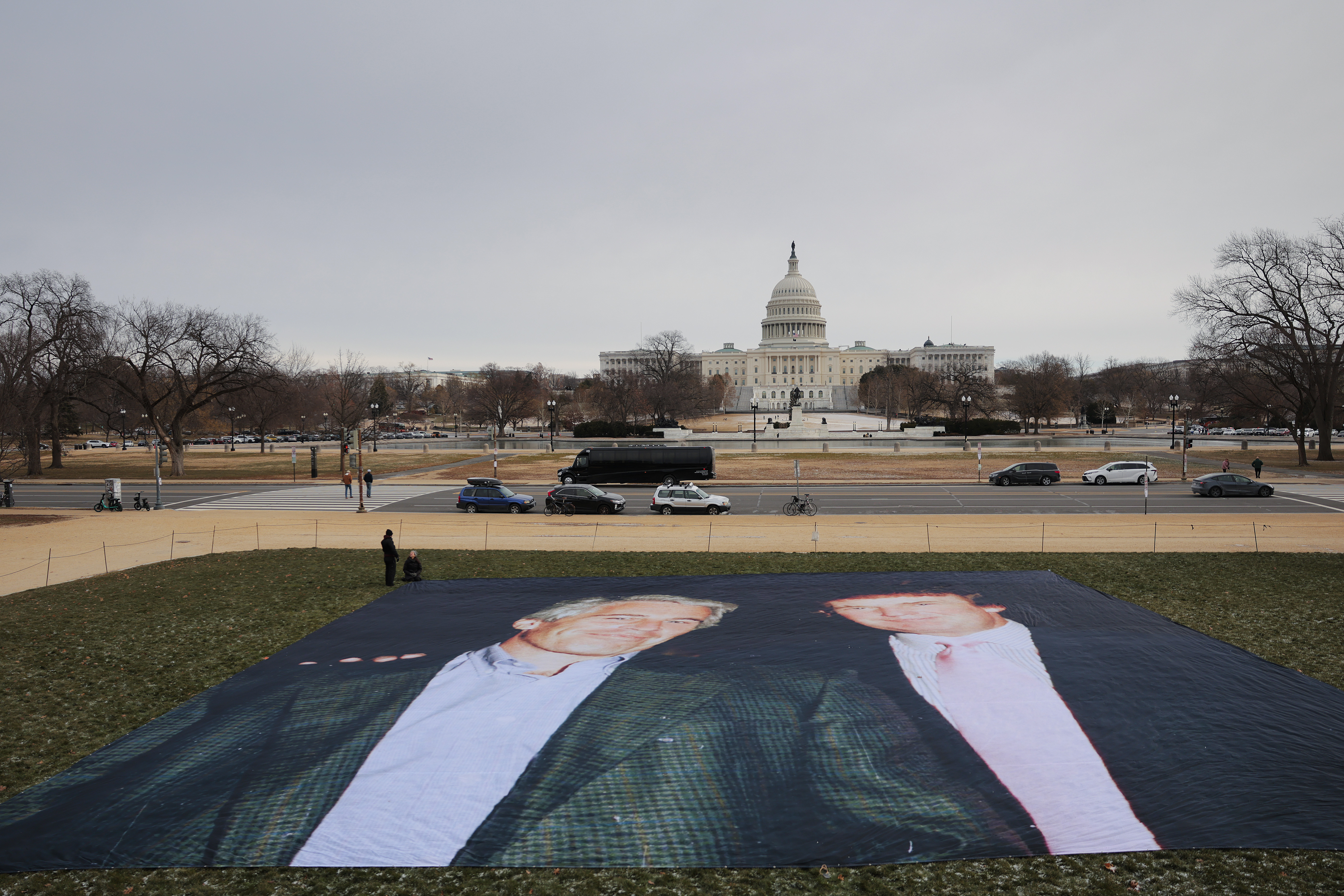 Activists spread a large tarp with a photo of Donald Trump and Jeffery Epstein in view of the U.S. Capitol.