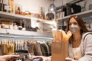 A woman pays for her purchases at a retail clothing store.