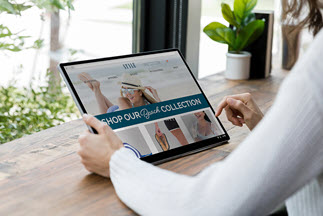 A woman browses a retail store's website to shop for clothes.