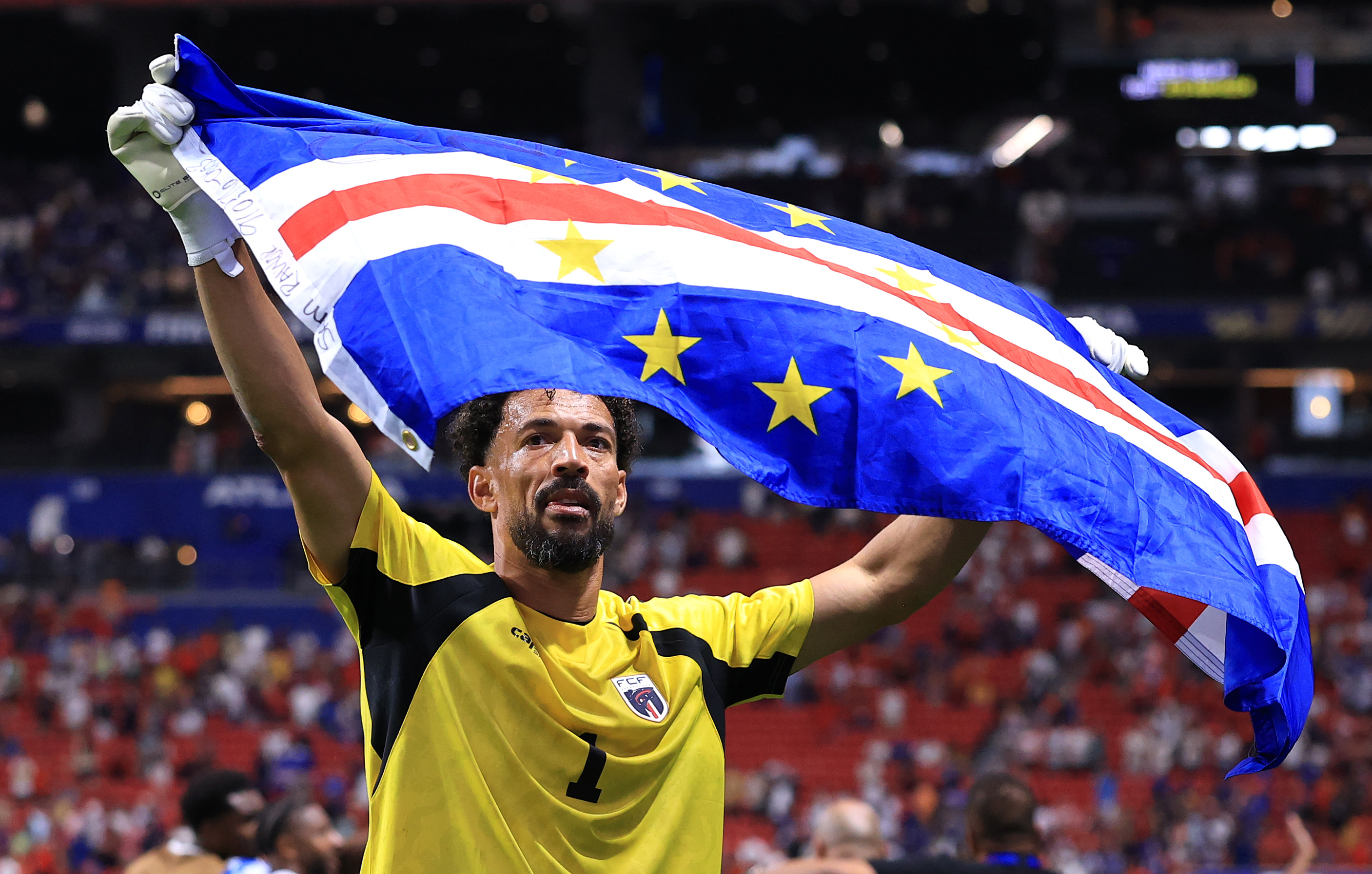 A Cape Verde player holds the country's flag during a World Cup match