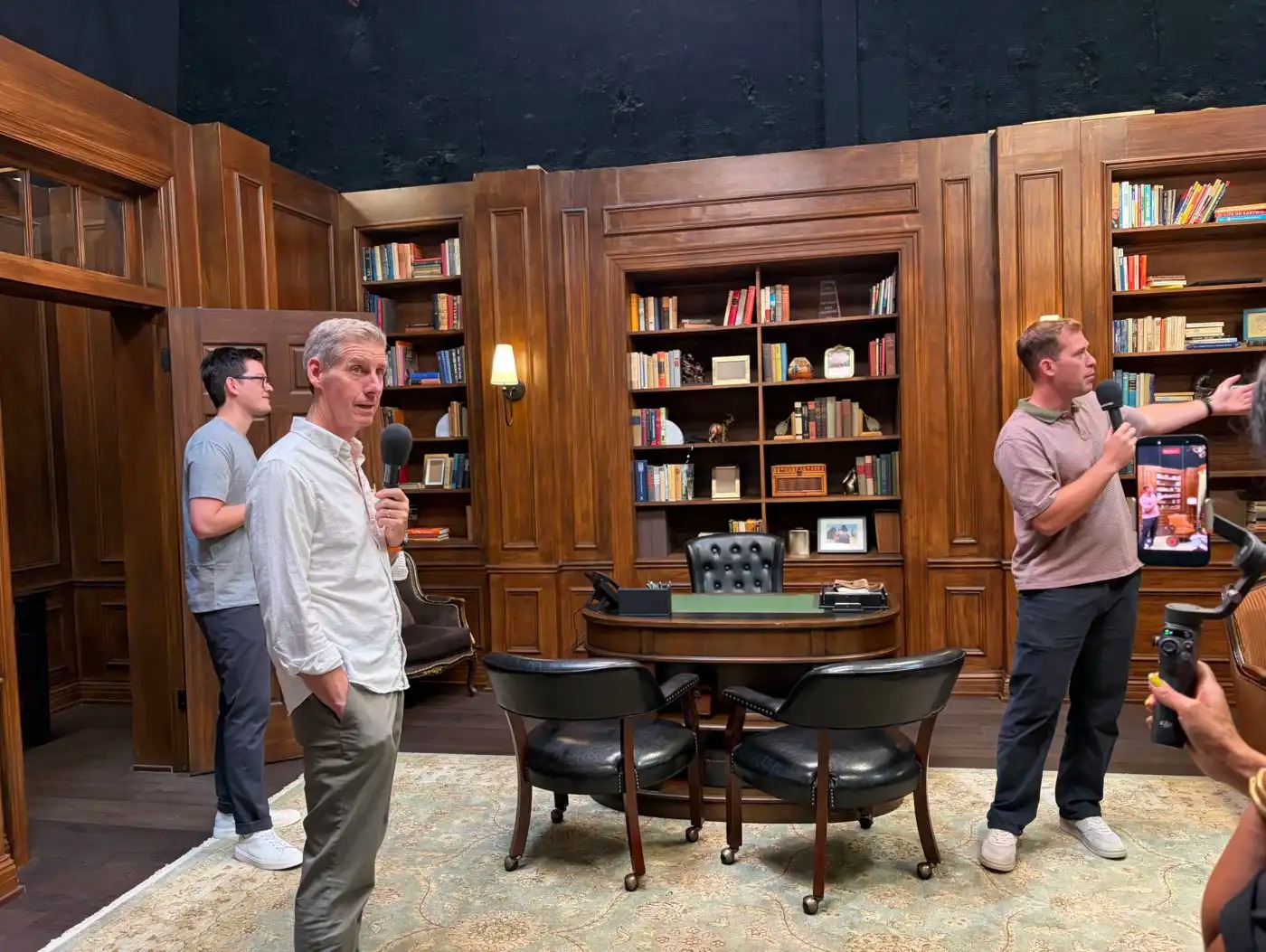 Kai Ryssdal walks through a set made to look like a library.