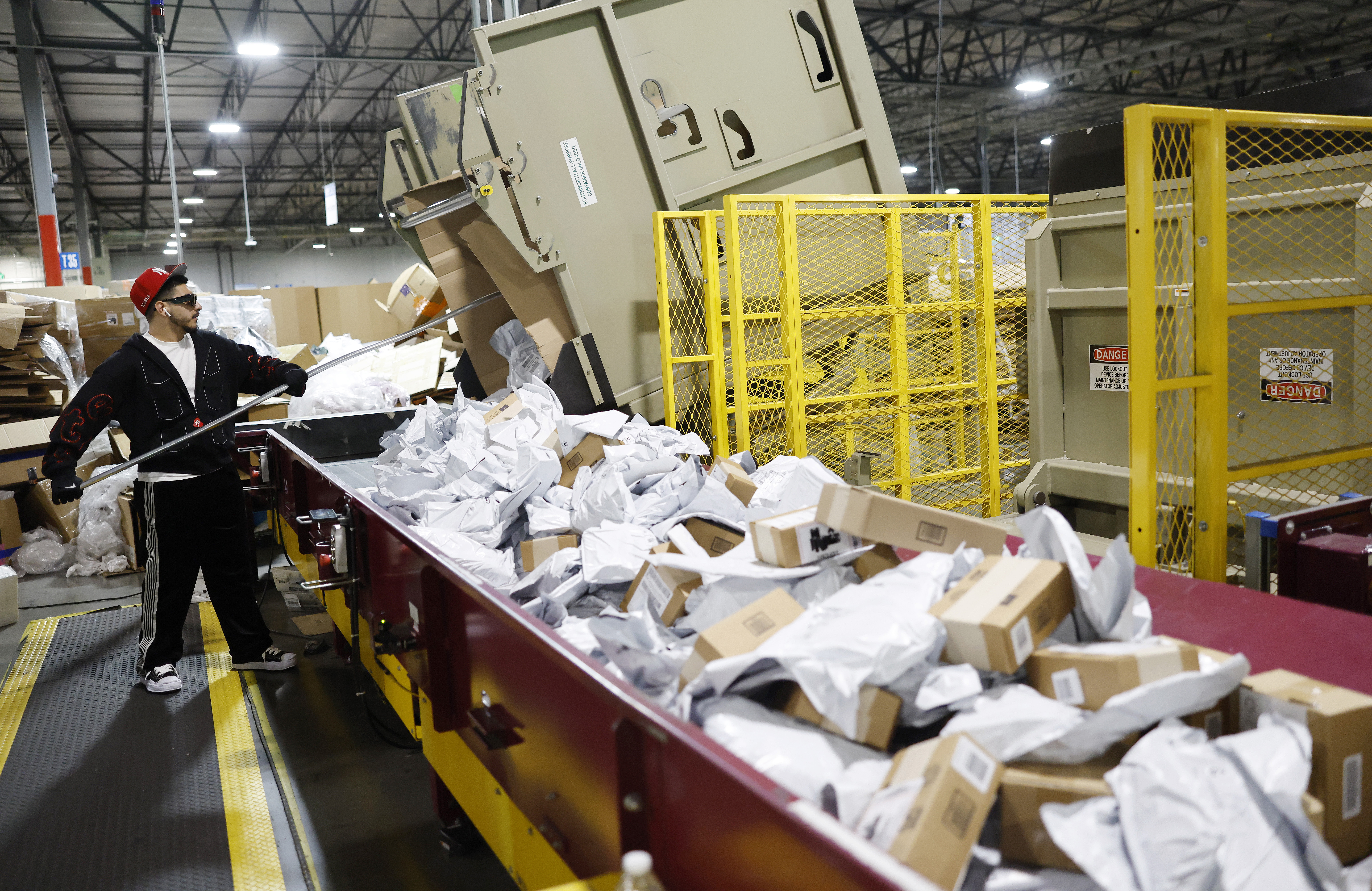 A man works the sorting machine at a postal distribution center