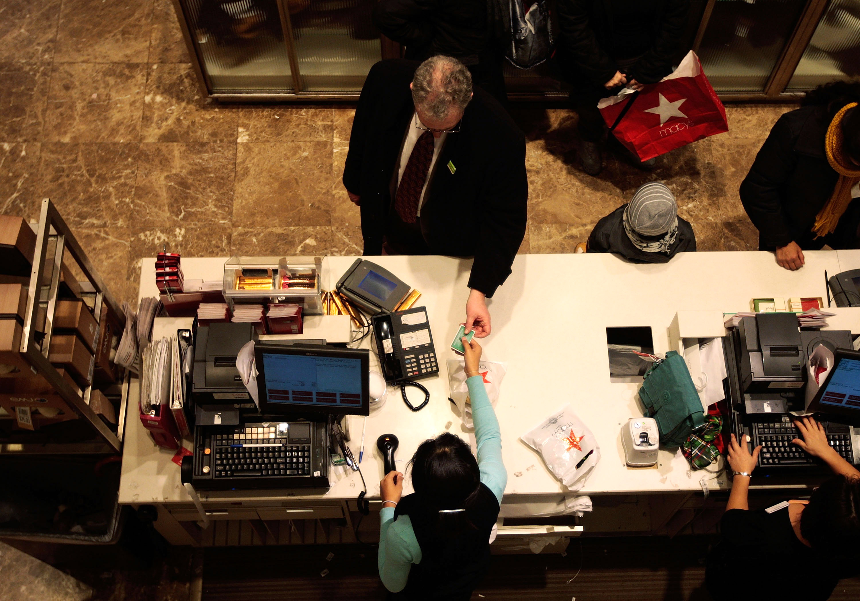 A man pays with a credit card at a Macys.