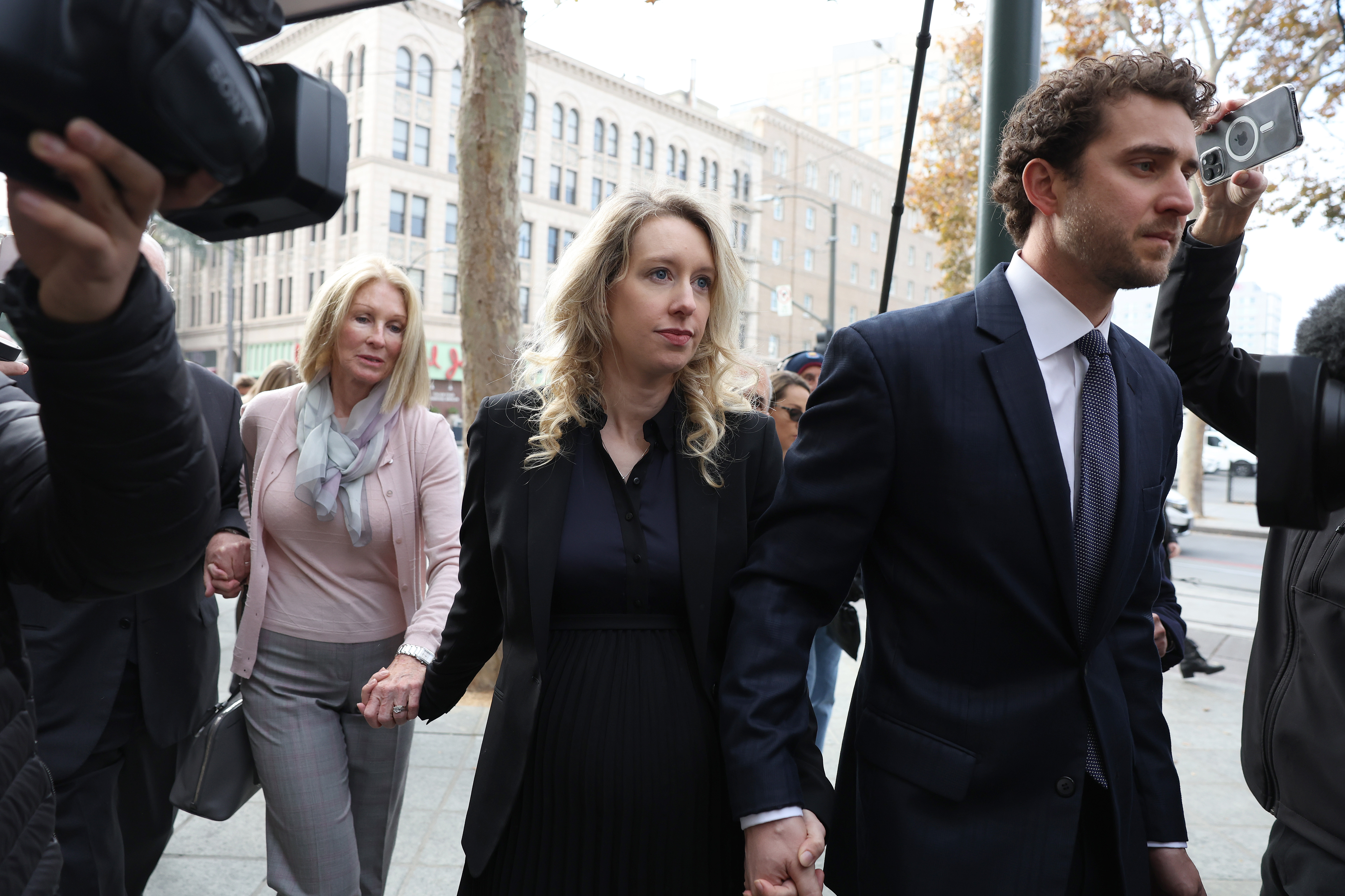 Elizabeth Holmes arrives at court with her partner and mother.