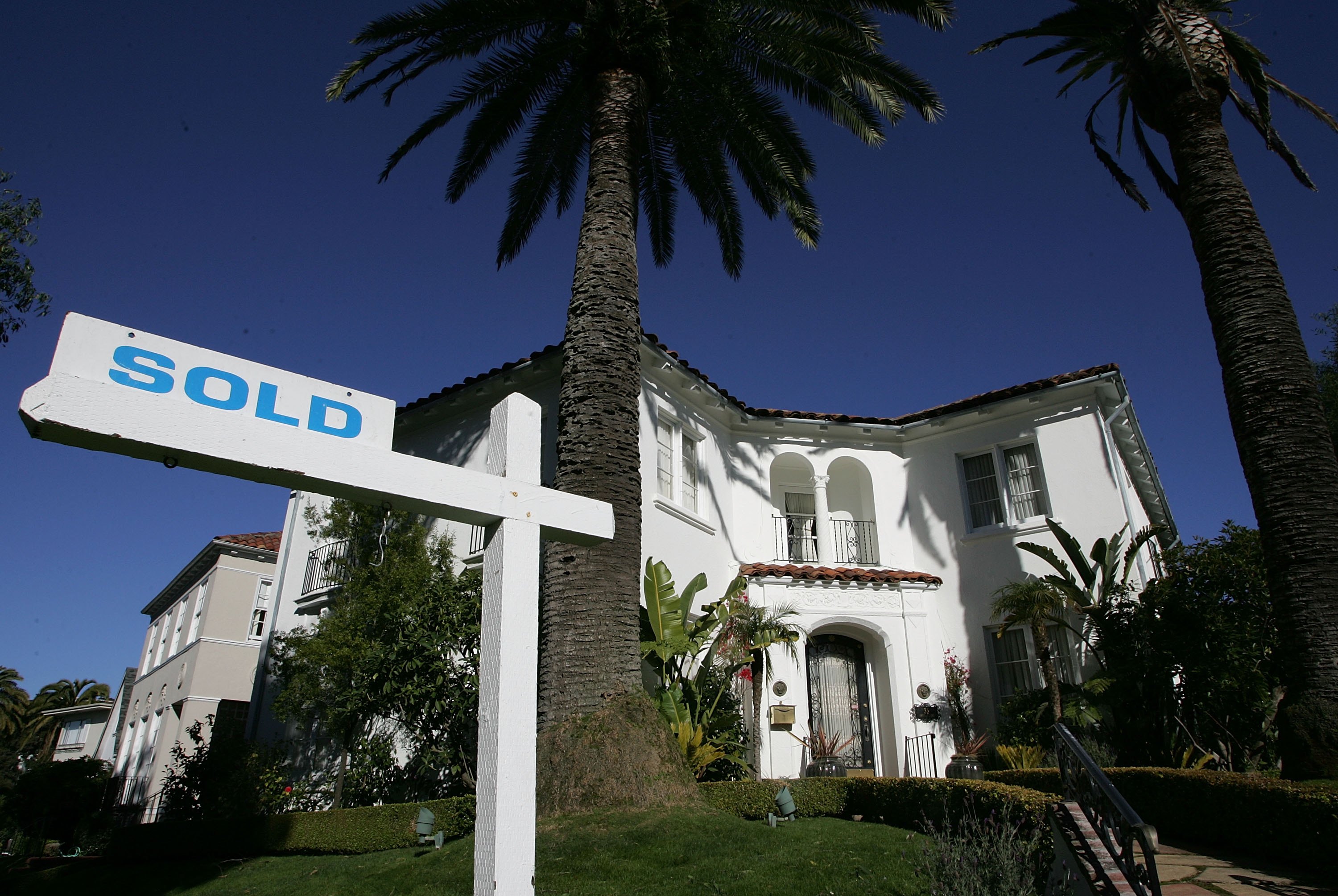 A large house with a sold sign.