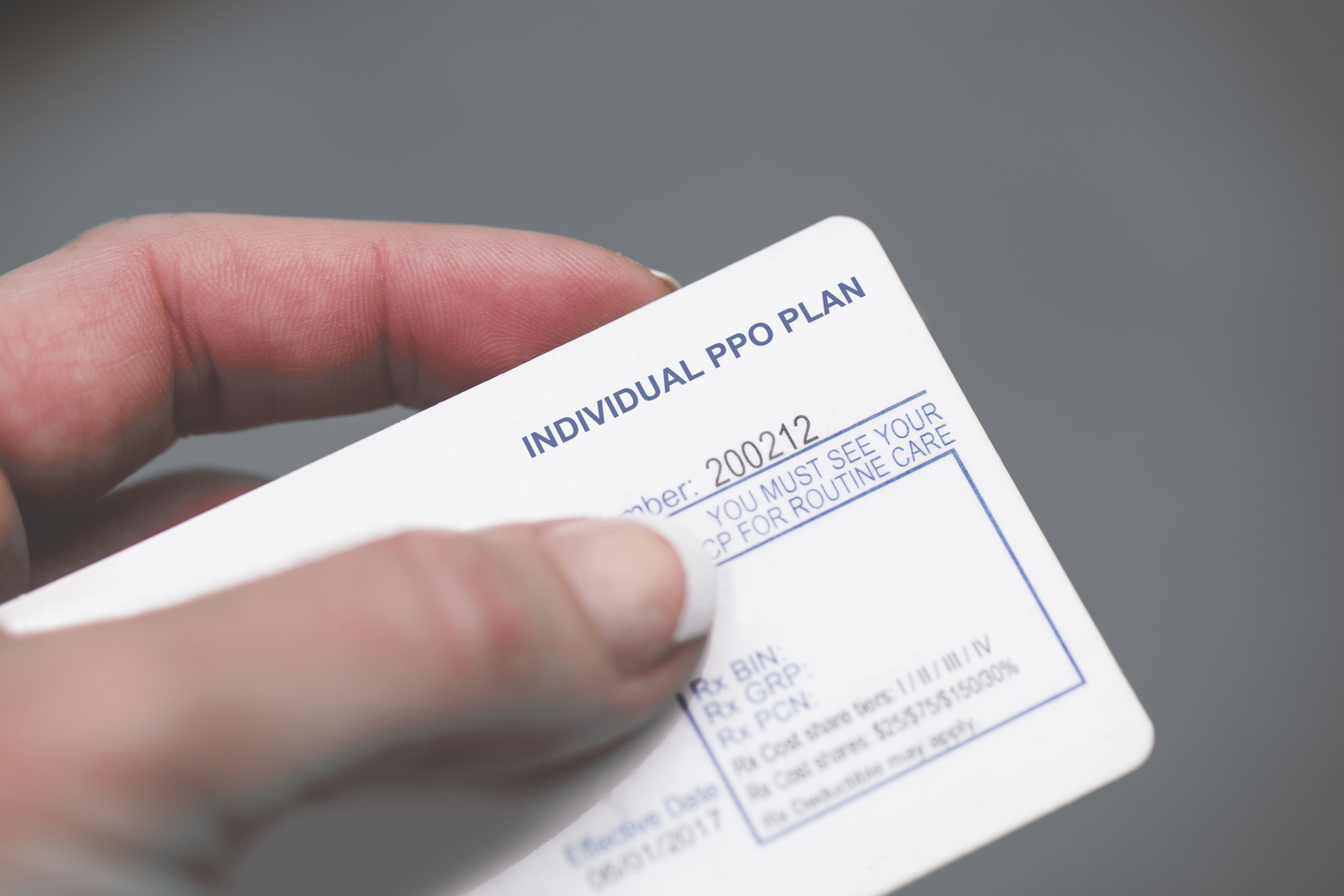 A hand holding an insurance card.
