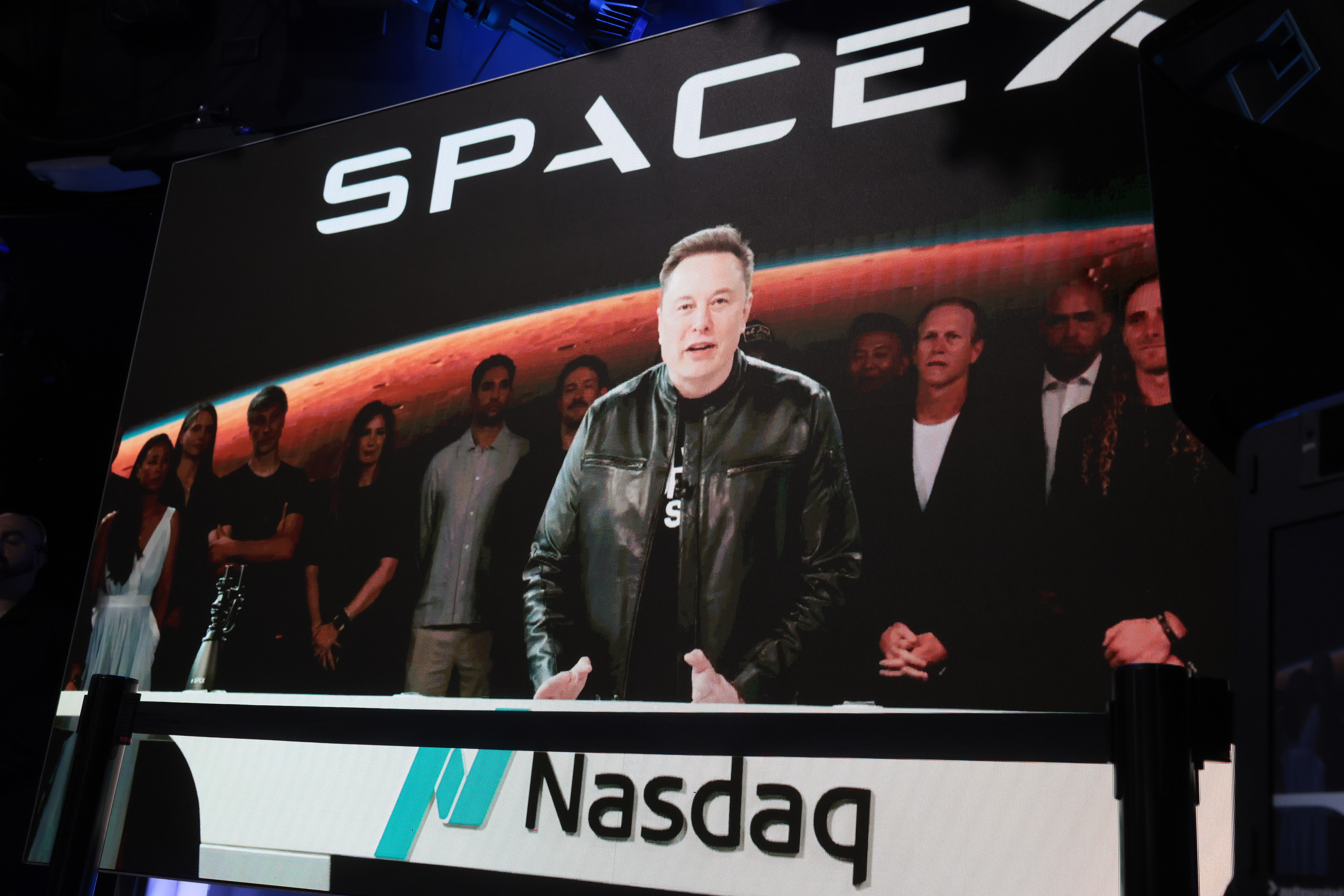 Elon Musk appears on a video screen during SpaceX's IPO.