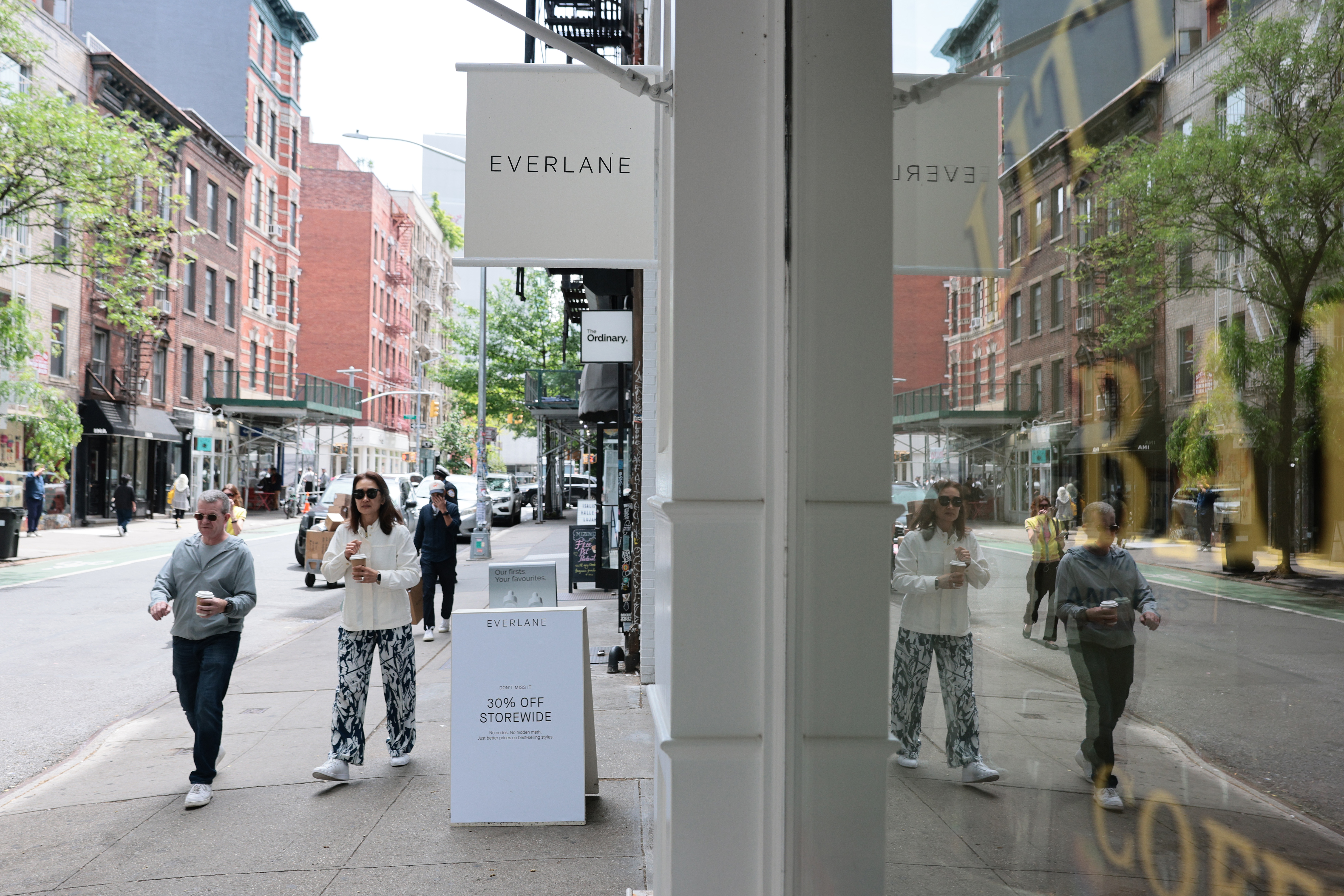 Pedestrians pass an Everlane store.