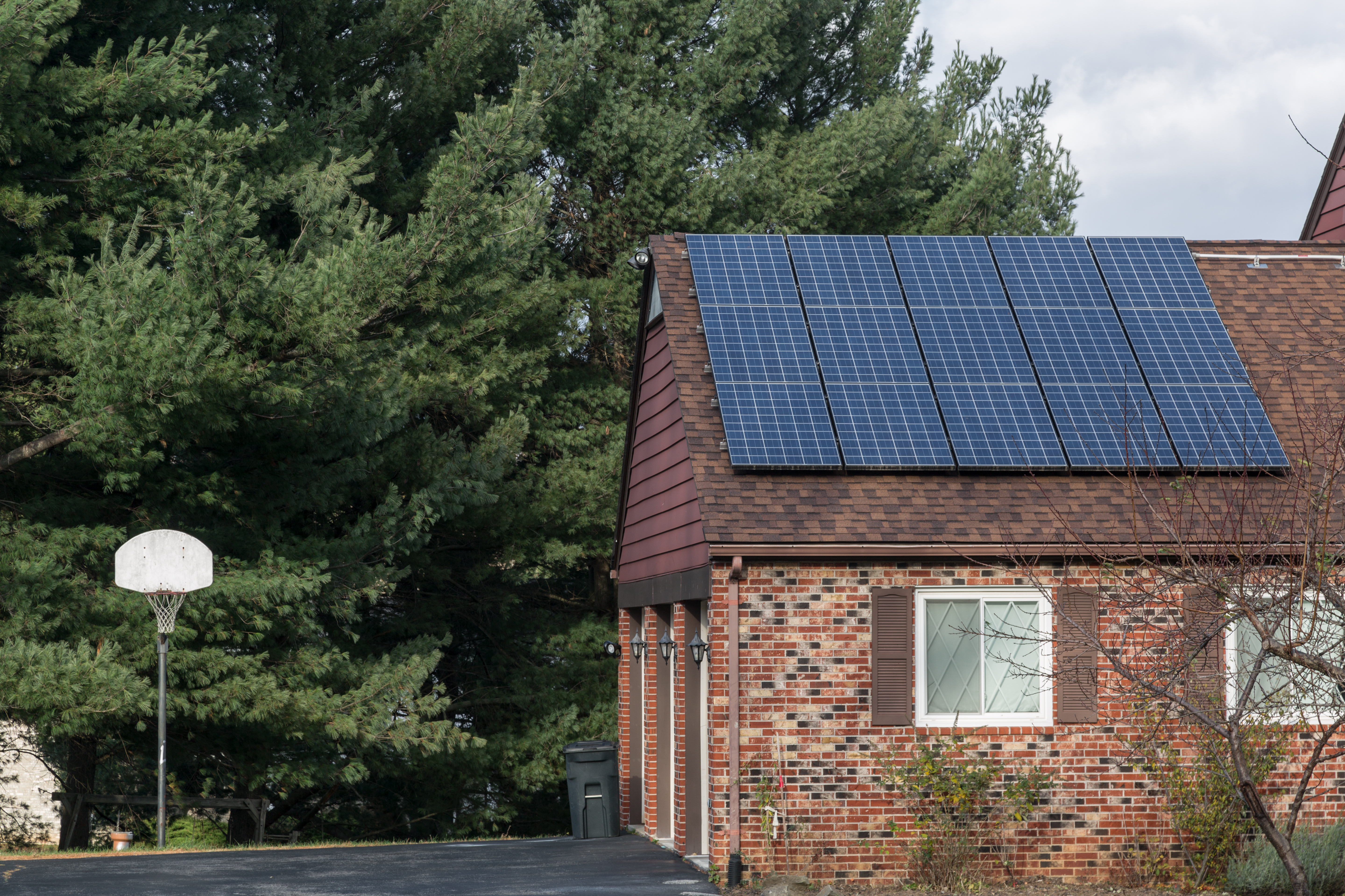Solar panels on the roof of a brick home.