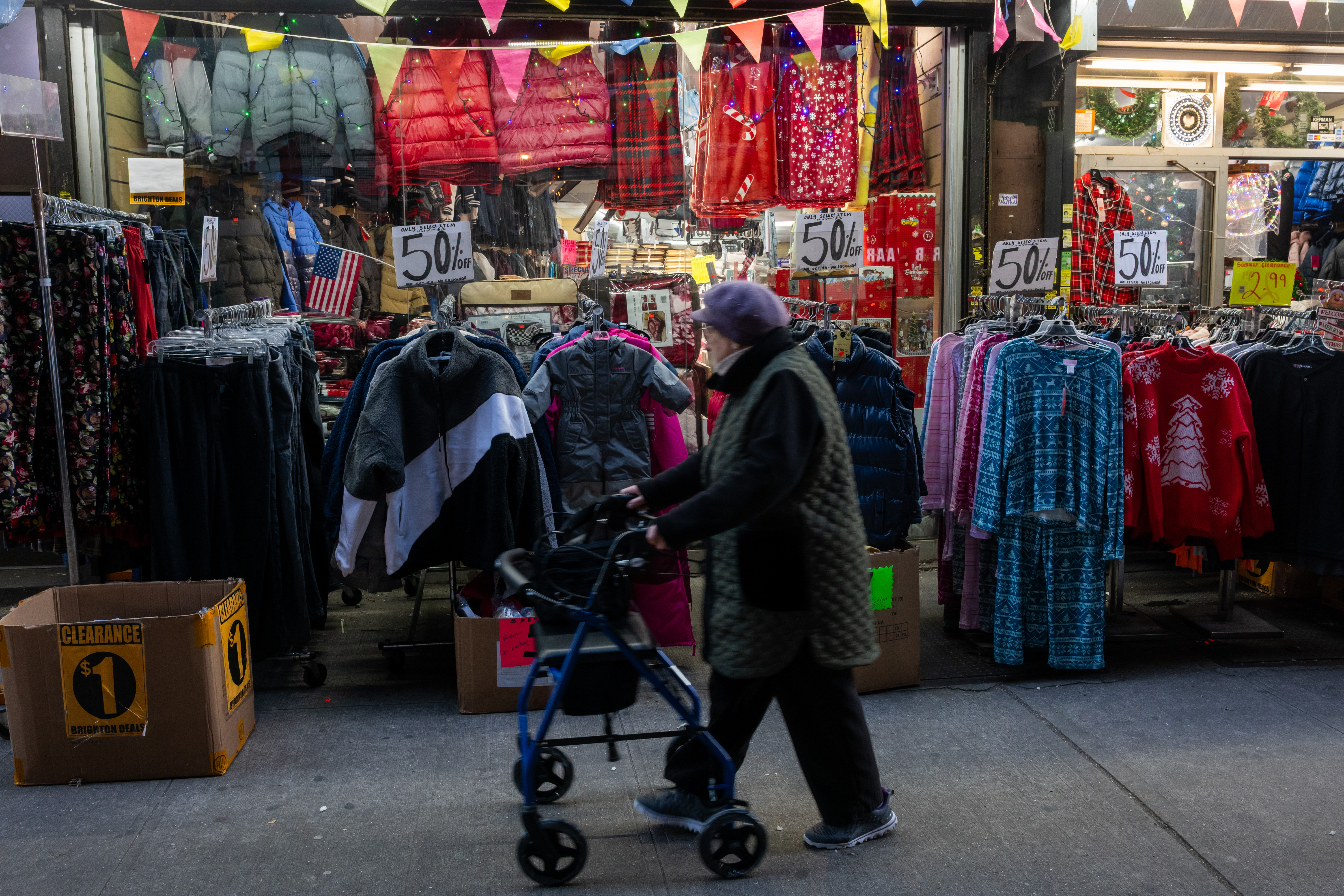 A man passes by a clothing store with many 
