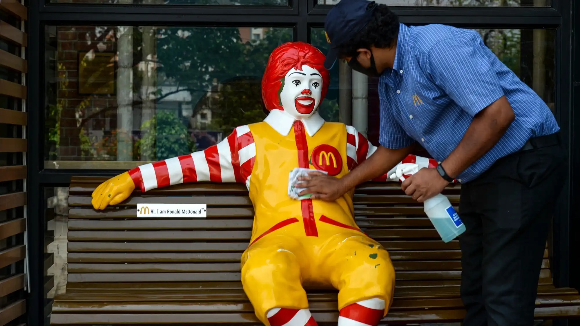 A worker polishes a life-size statue of Ronald McDonald.