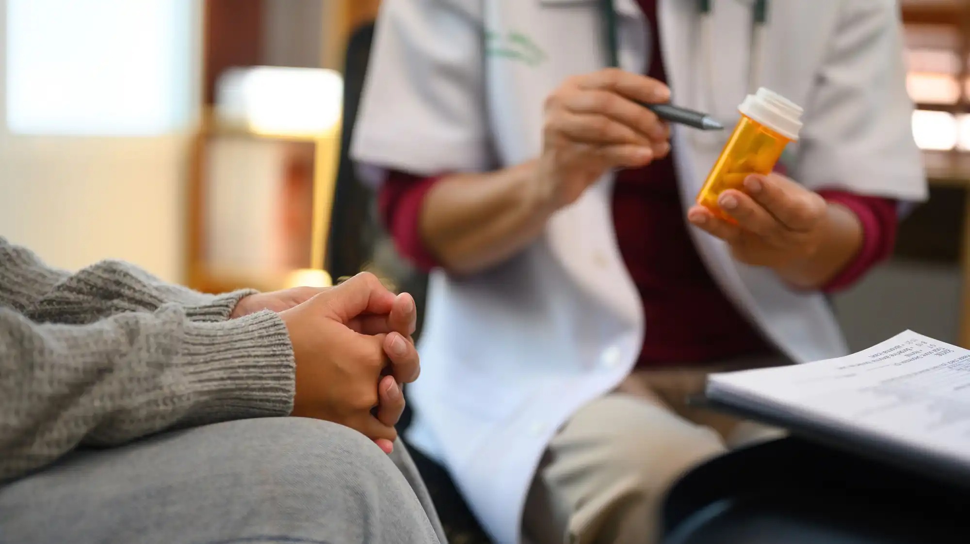 A stock photo shows a patient and doctor discussing medication.