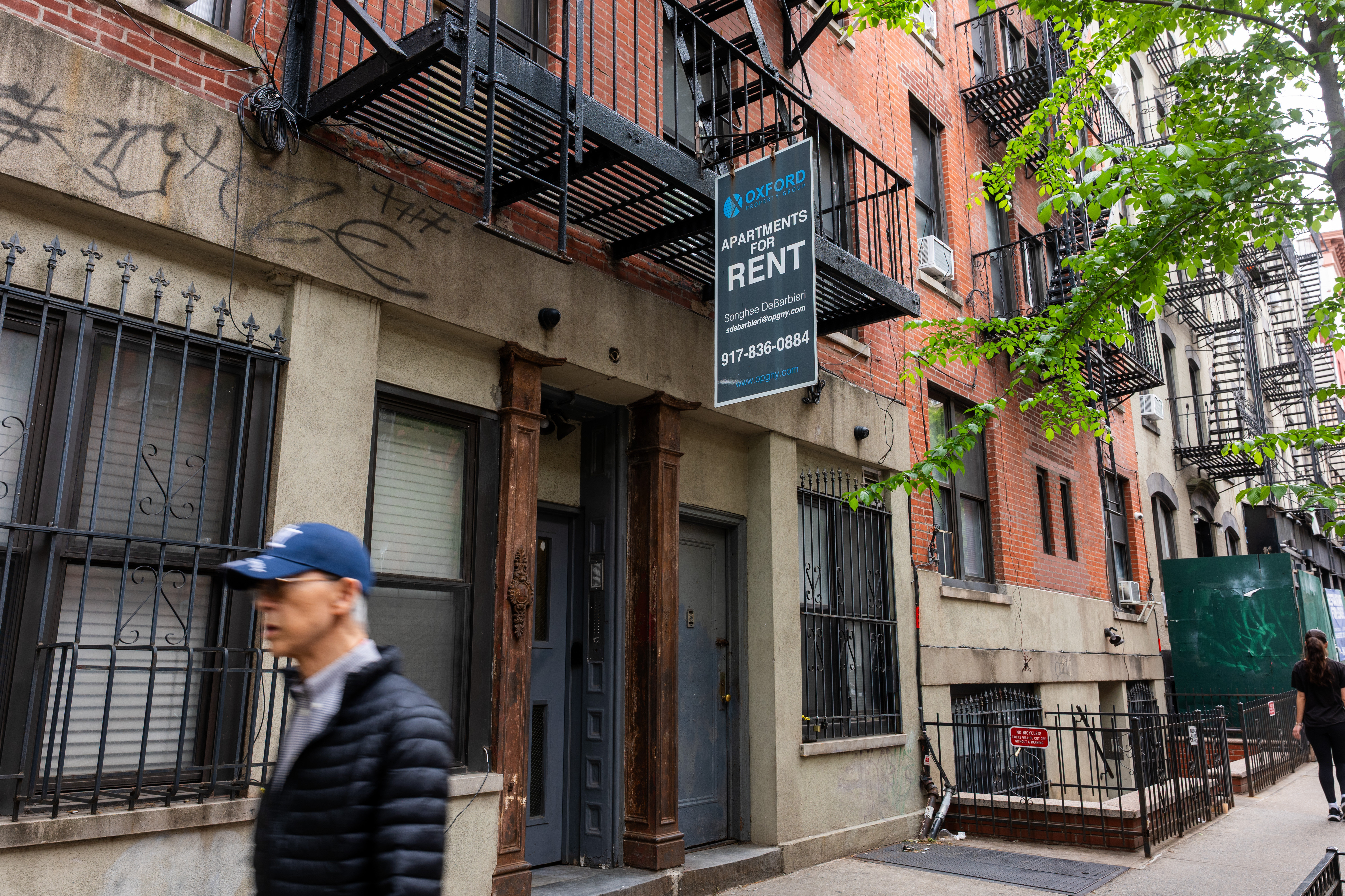 A man rushes by an apartment building with a 