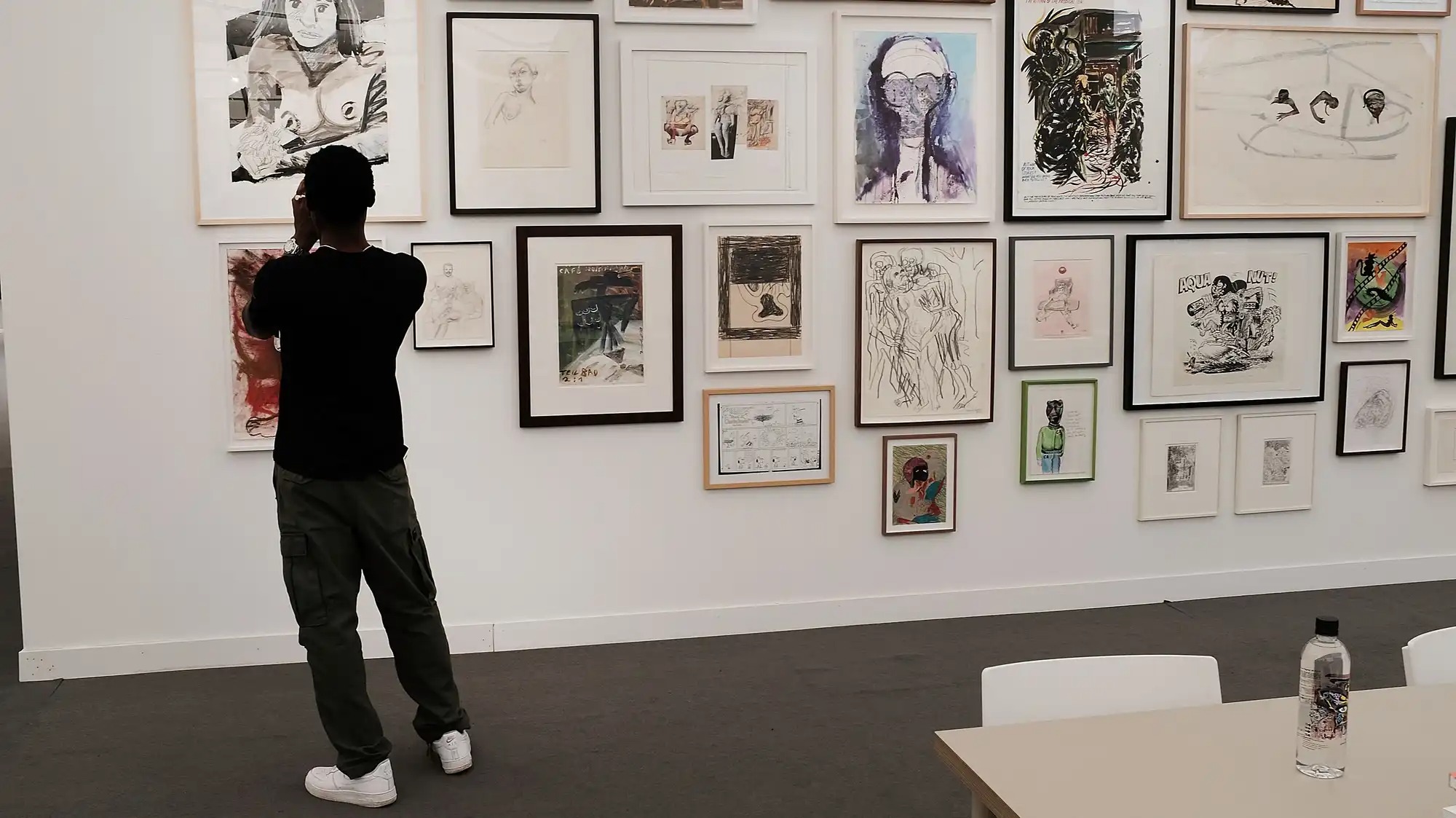 A man looks at art on a gallery wall