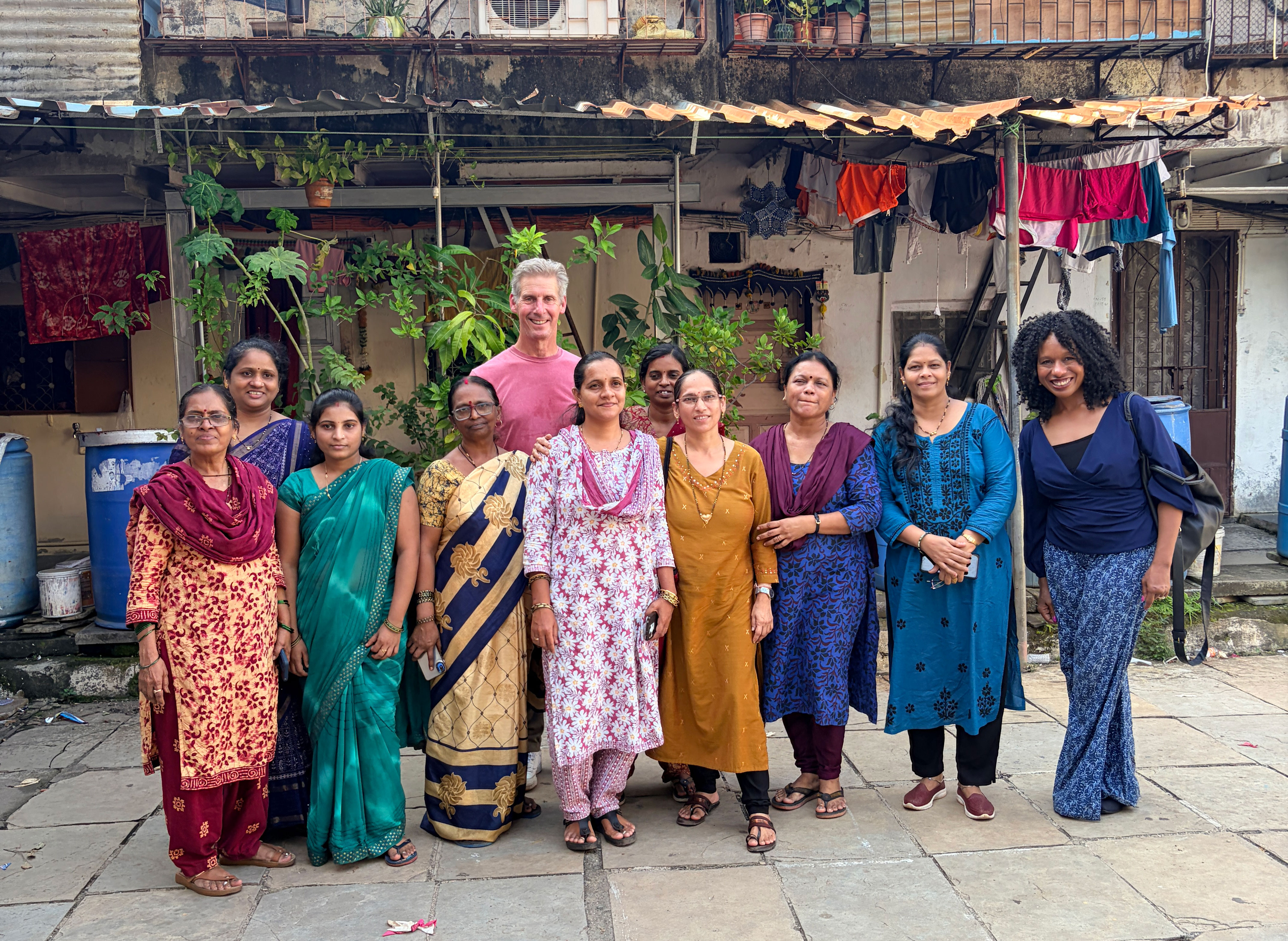 Kai Ryssdal and Nela Richardson pose for a photo with the women of MarketPlace