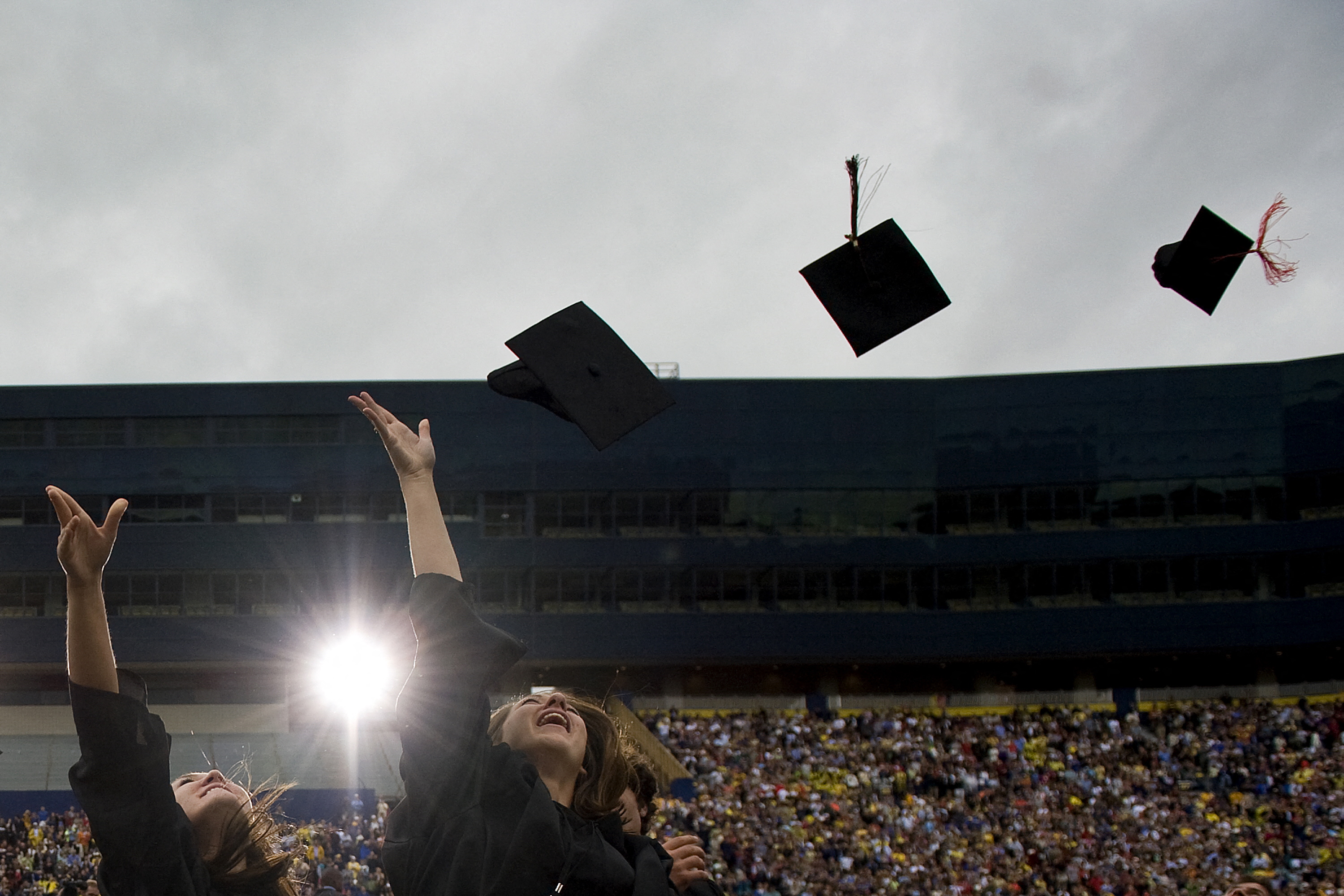 New graduates throw their caps in the air.