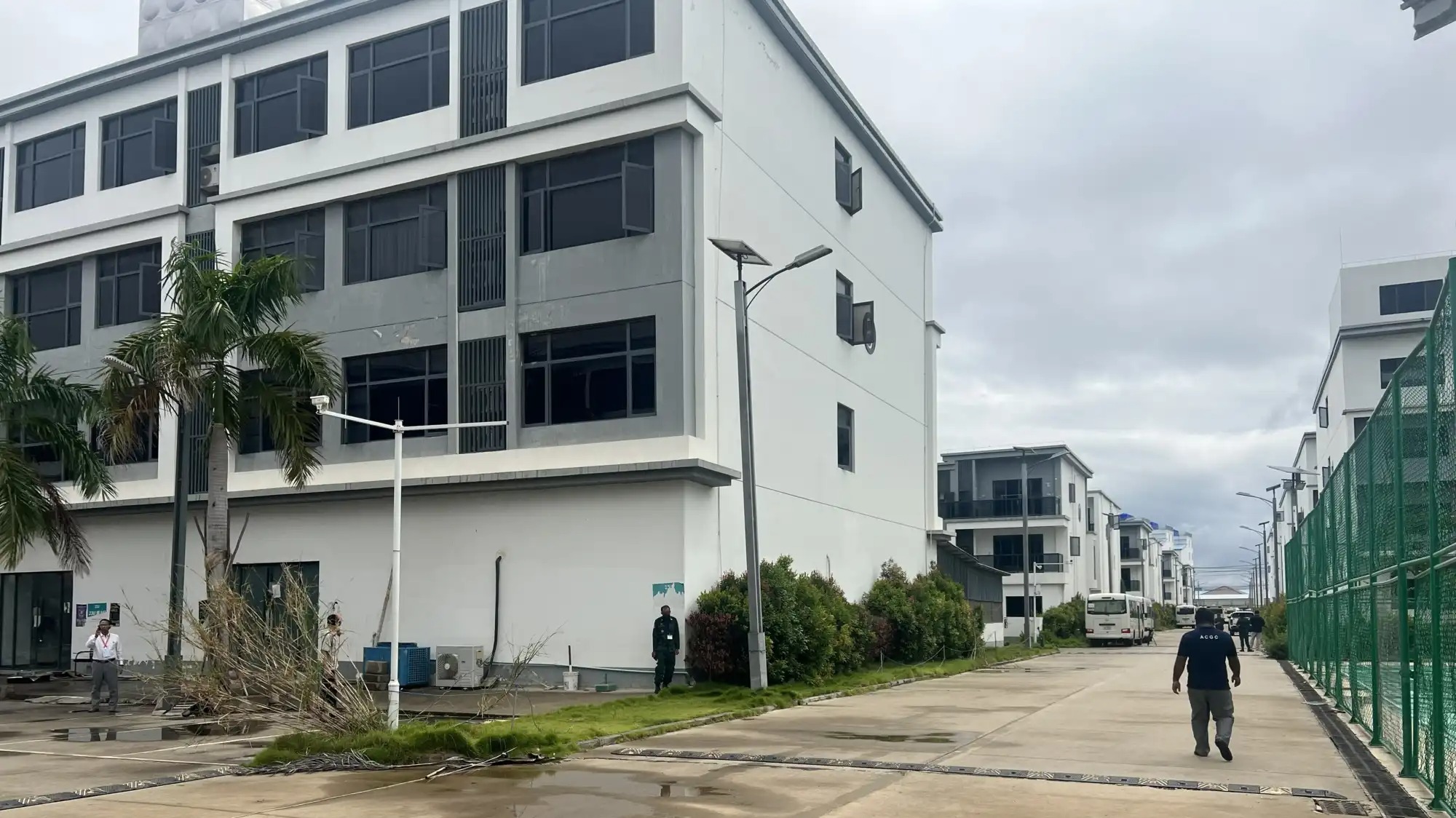 A man walks through an abandoned, run down office park.