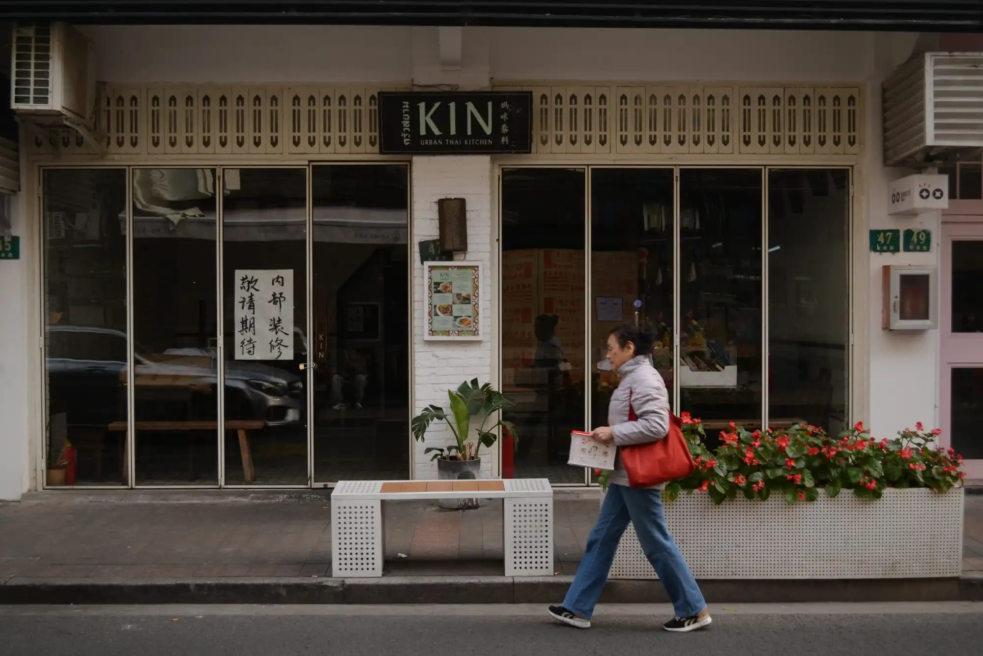 A woman walks by a shuttered restaurant in Shanghai