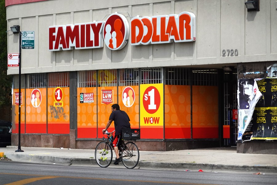 A bicyclist rides past a Family Dollar store. 