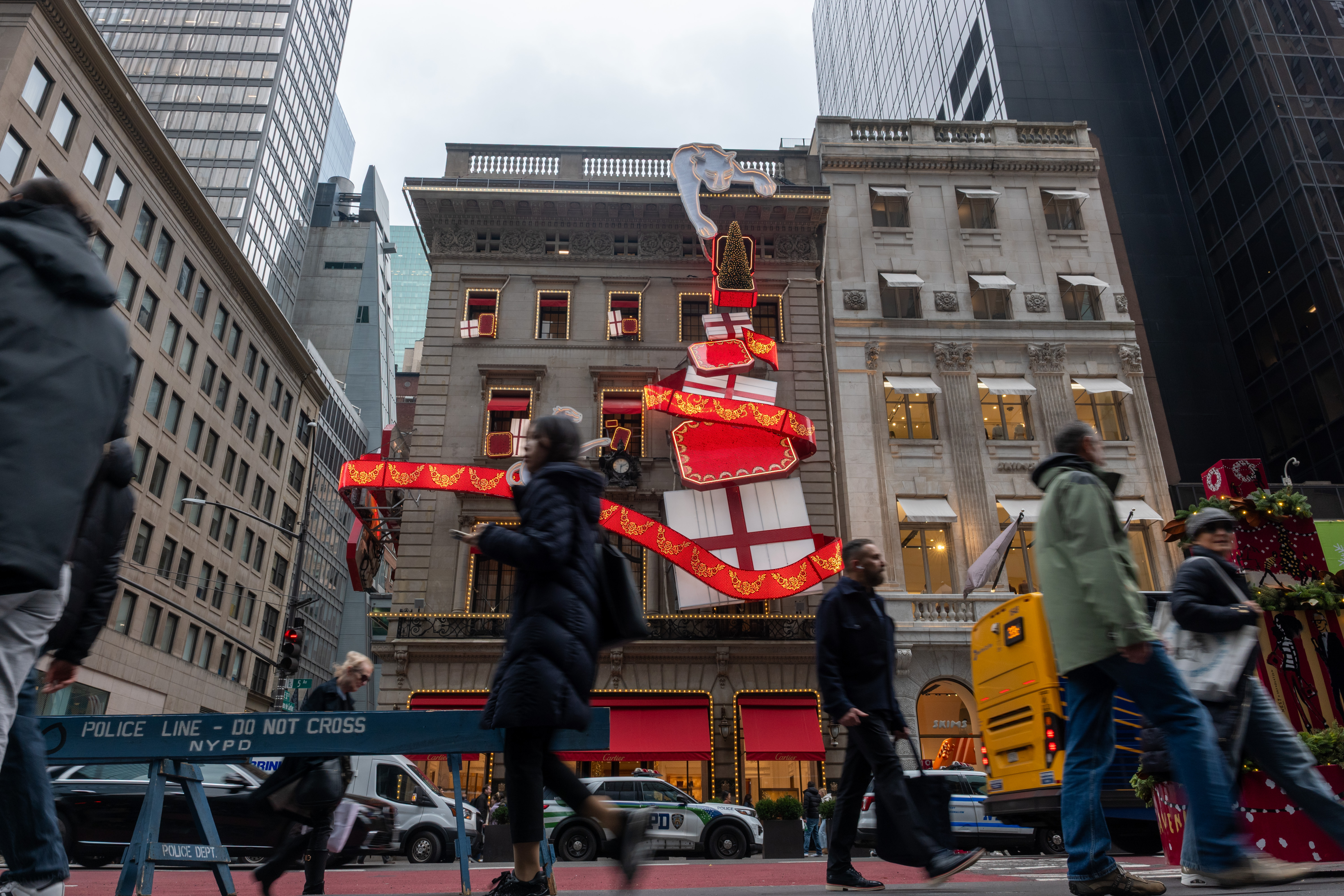 Pedestrians pass a holiday display.