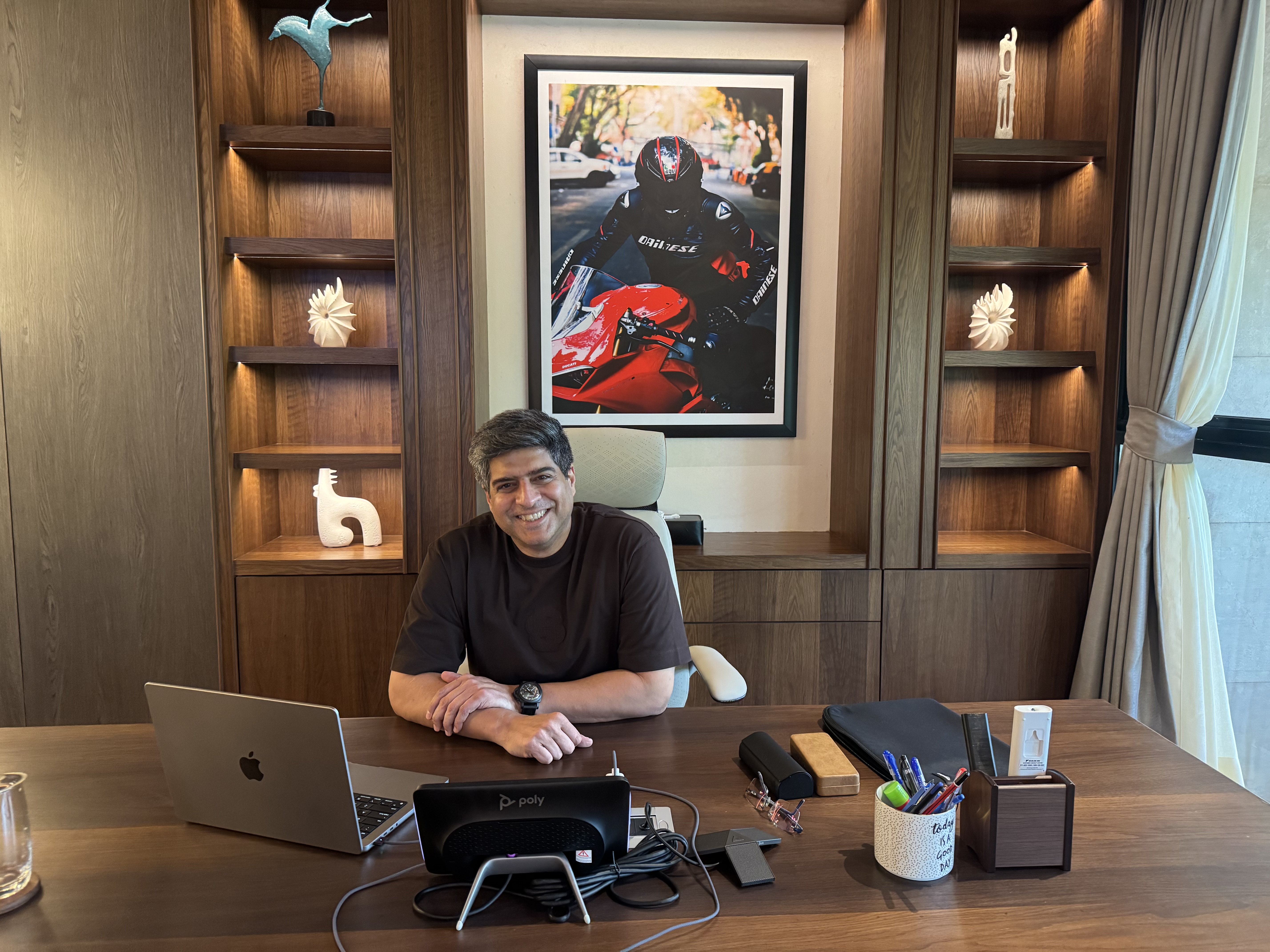 A man smiles at a desk.