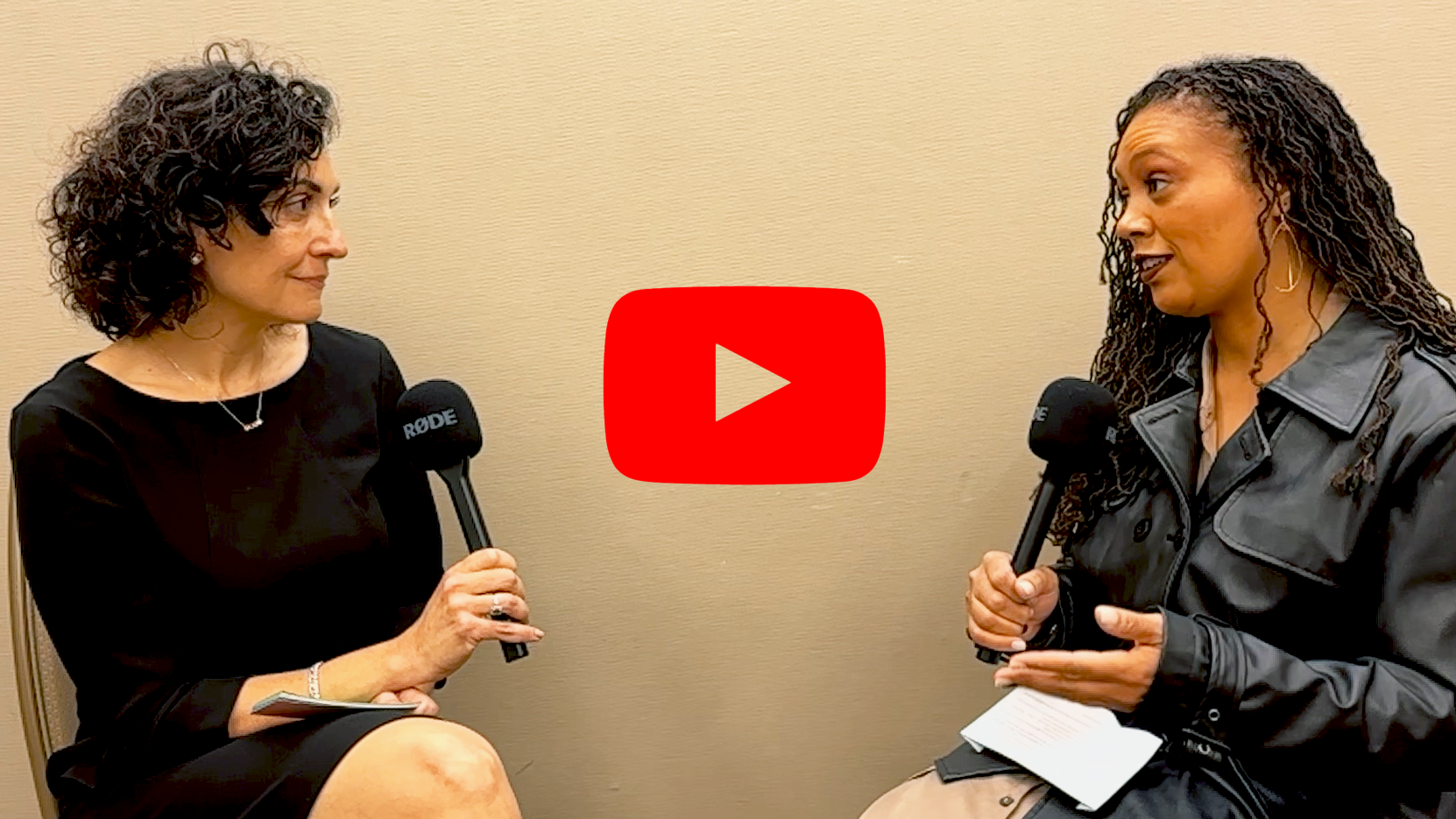 Kimberly Adams and Nadine Farid Johnson speak to each other, holding microphones.