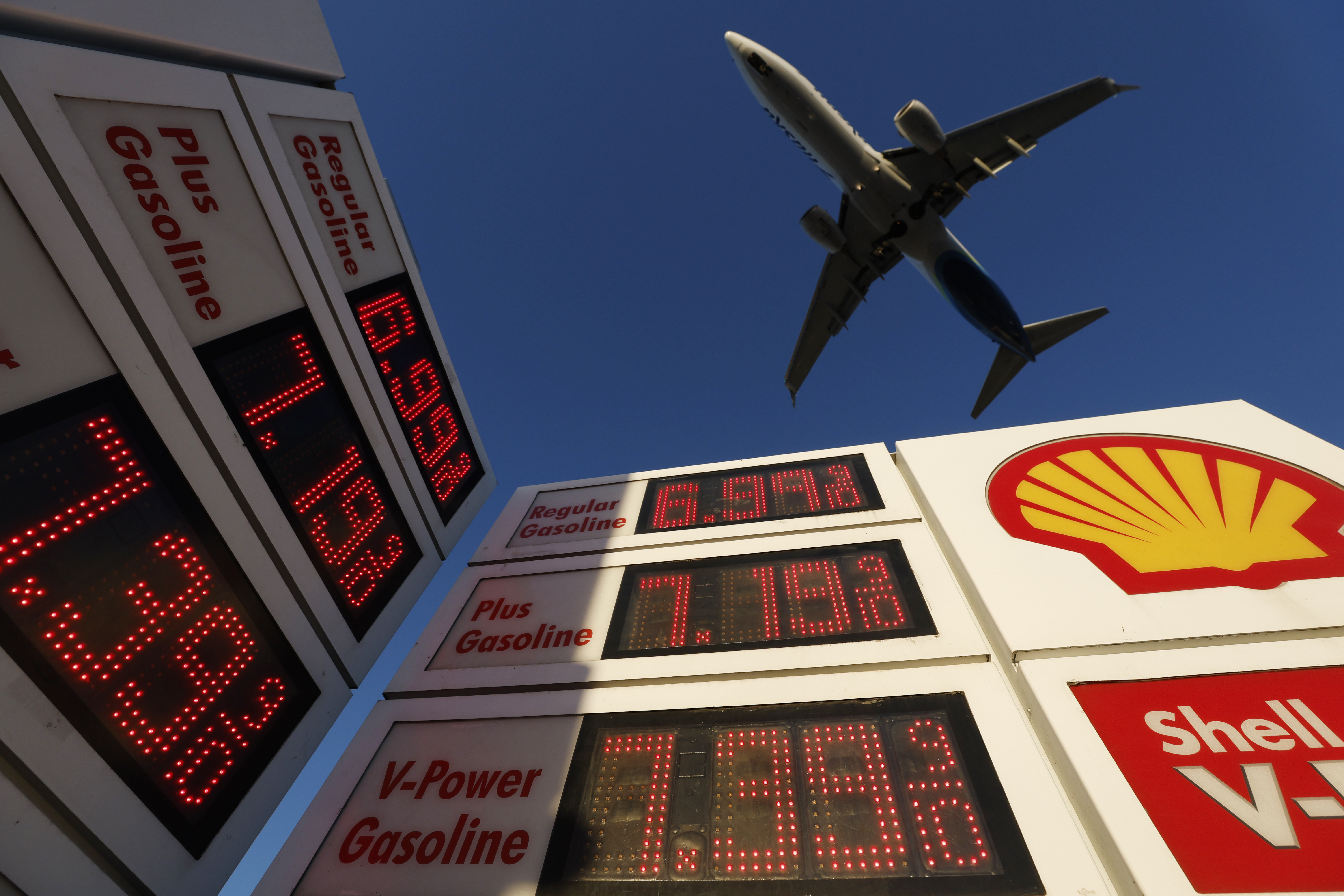 An Alaska Airlines Boeing 737 airplane approaches San Diego International Airport above a Shell gas station displaying prices over seven dollars a gallon for gas on October 9, 2026 in San Diego, California. 