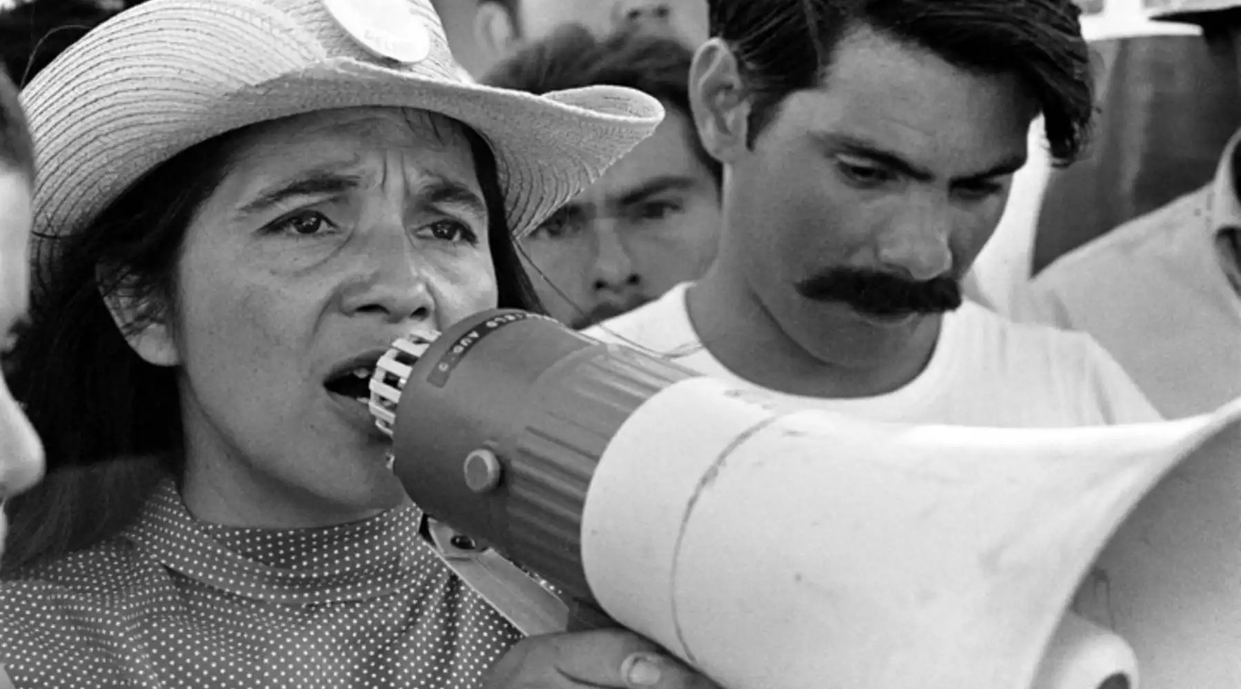An archival photo of a woman speaking into a megaphone.