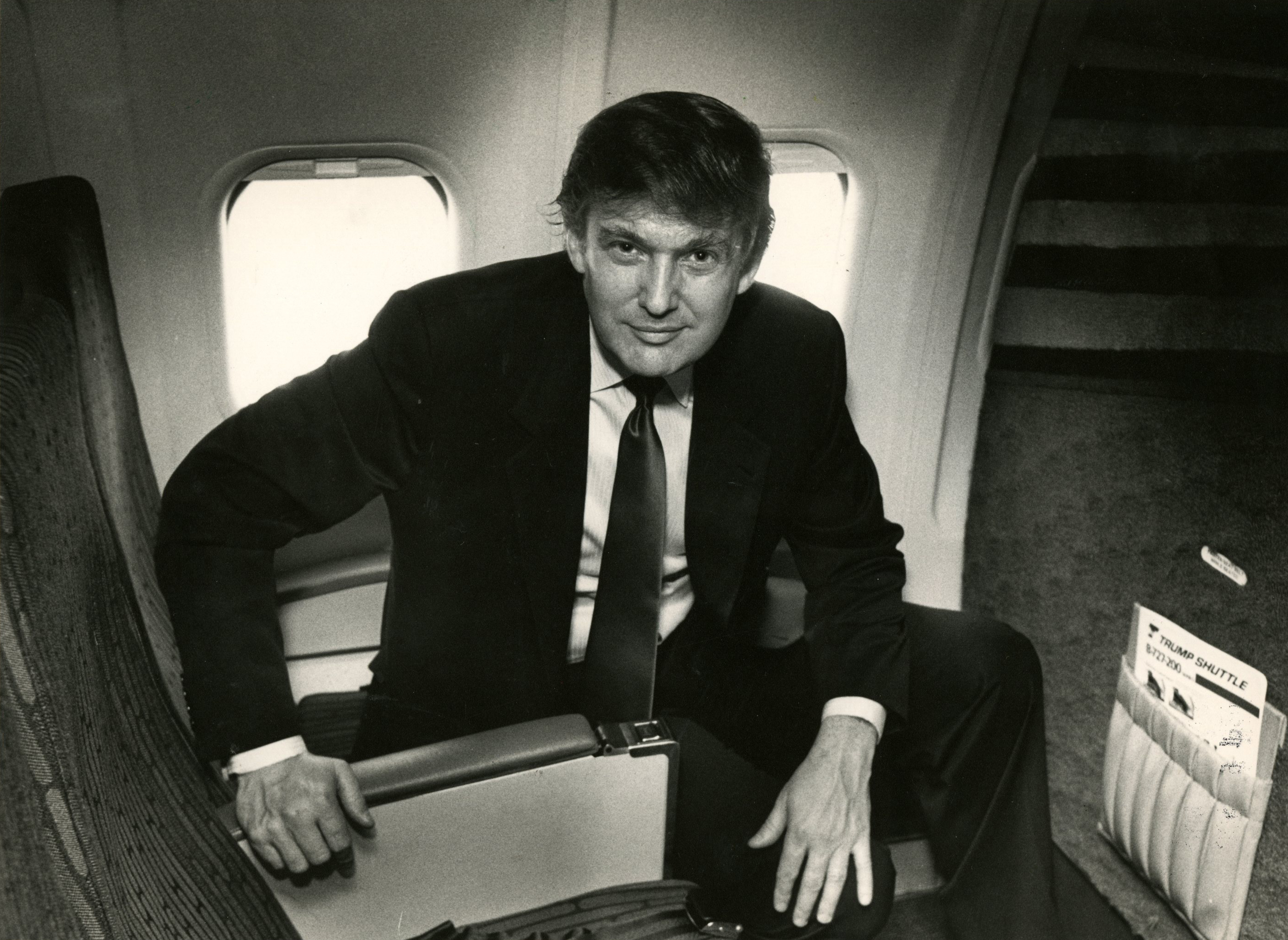 Trump poses on a Trump Shuttle plane in 1989.