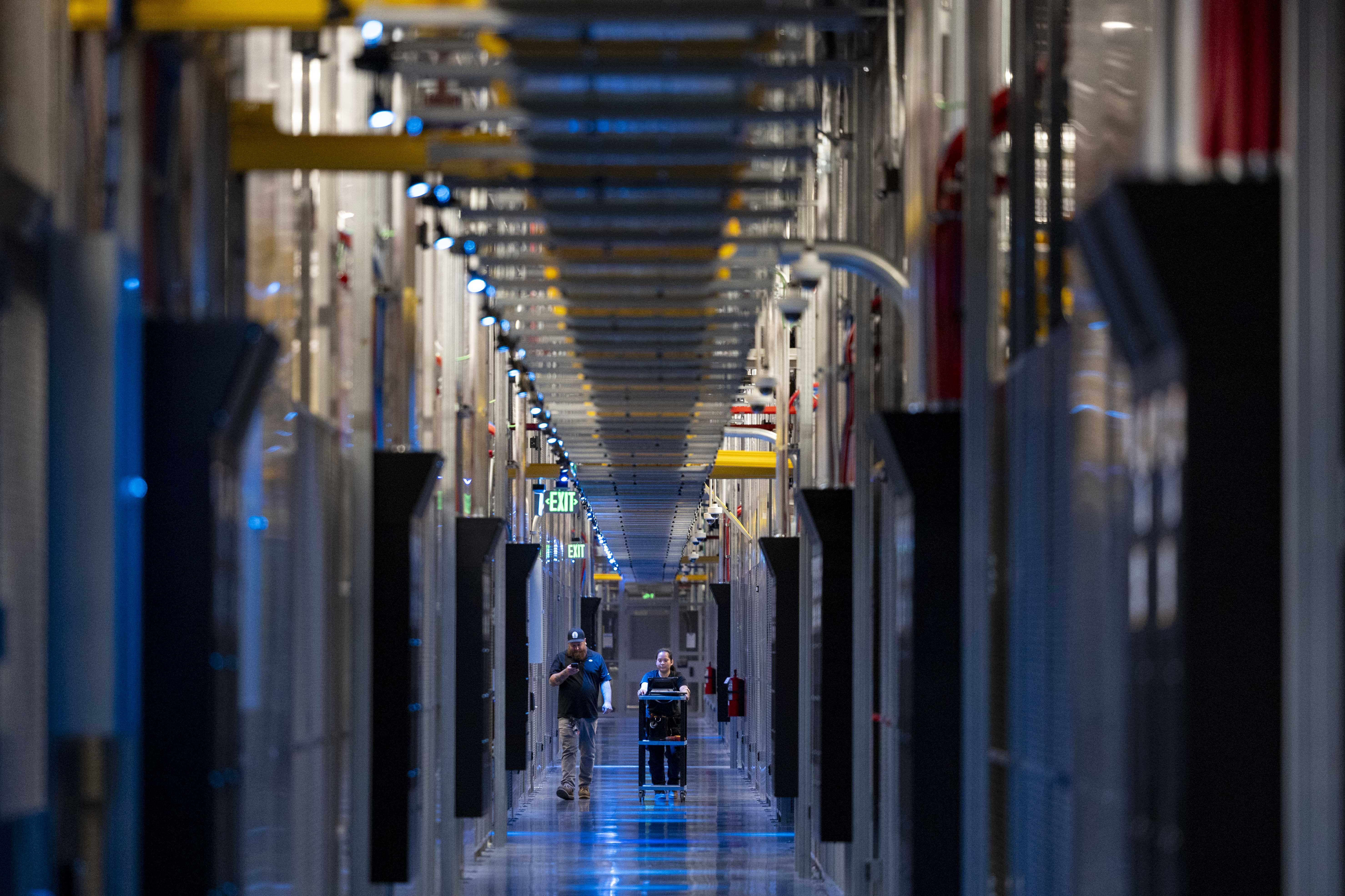 Workers walk through a data center