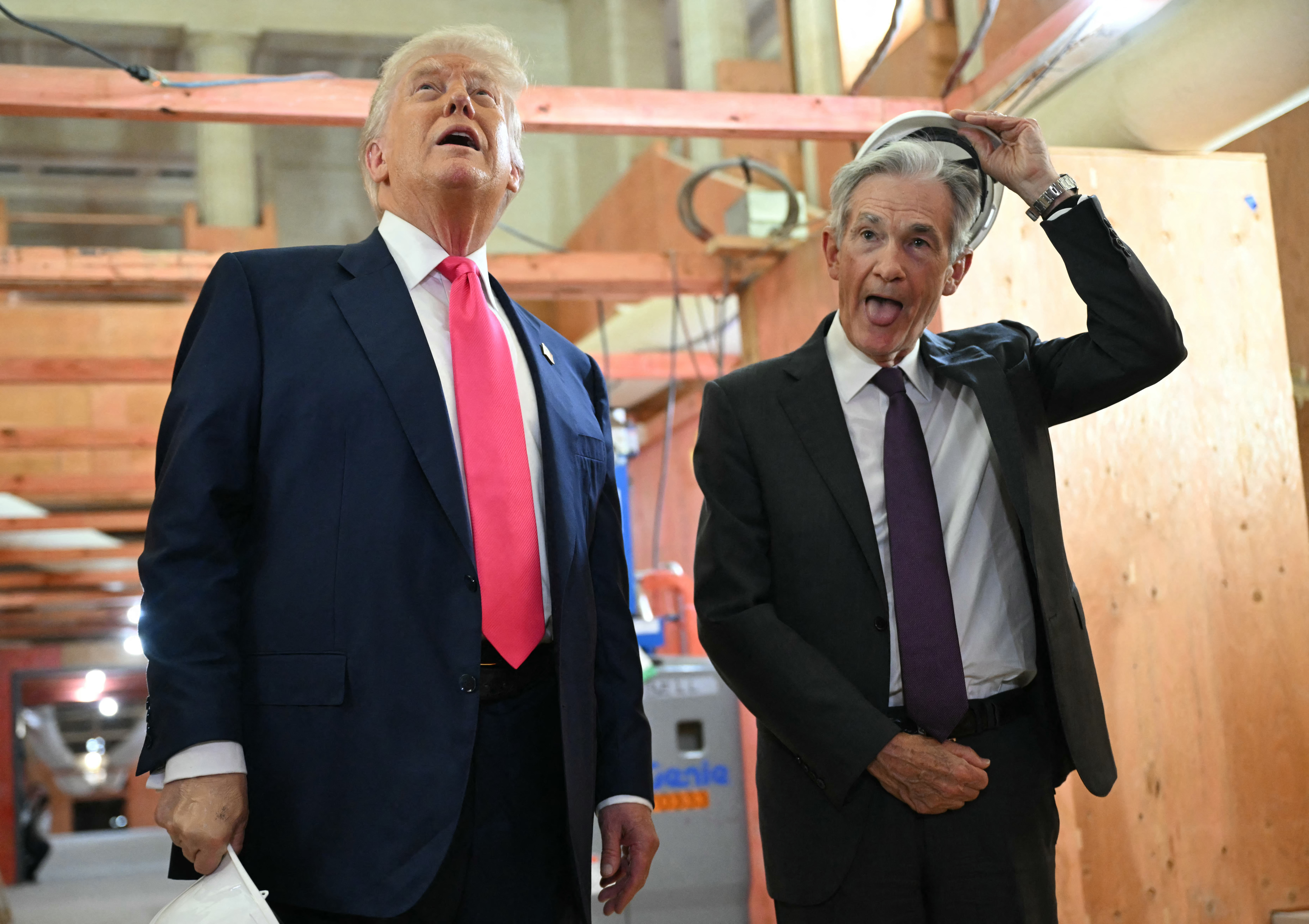 President Donald Trump and then-Federal Reserve Chair Jerome Powell. Trump is speaking while Powell is sticking out his tongue in a candid moment.