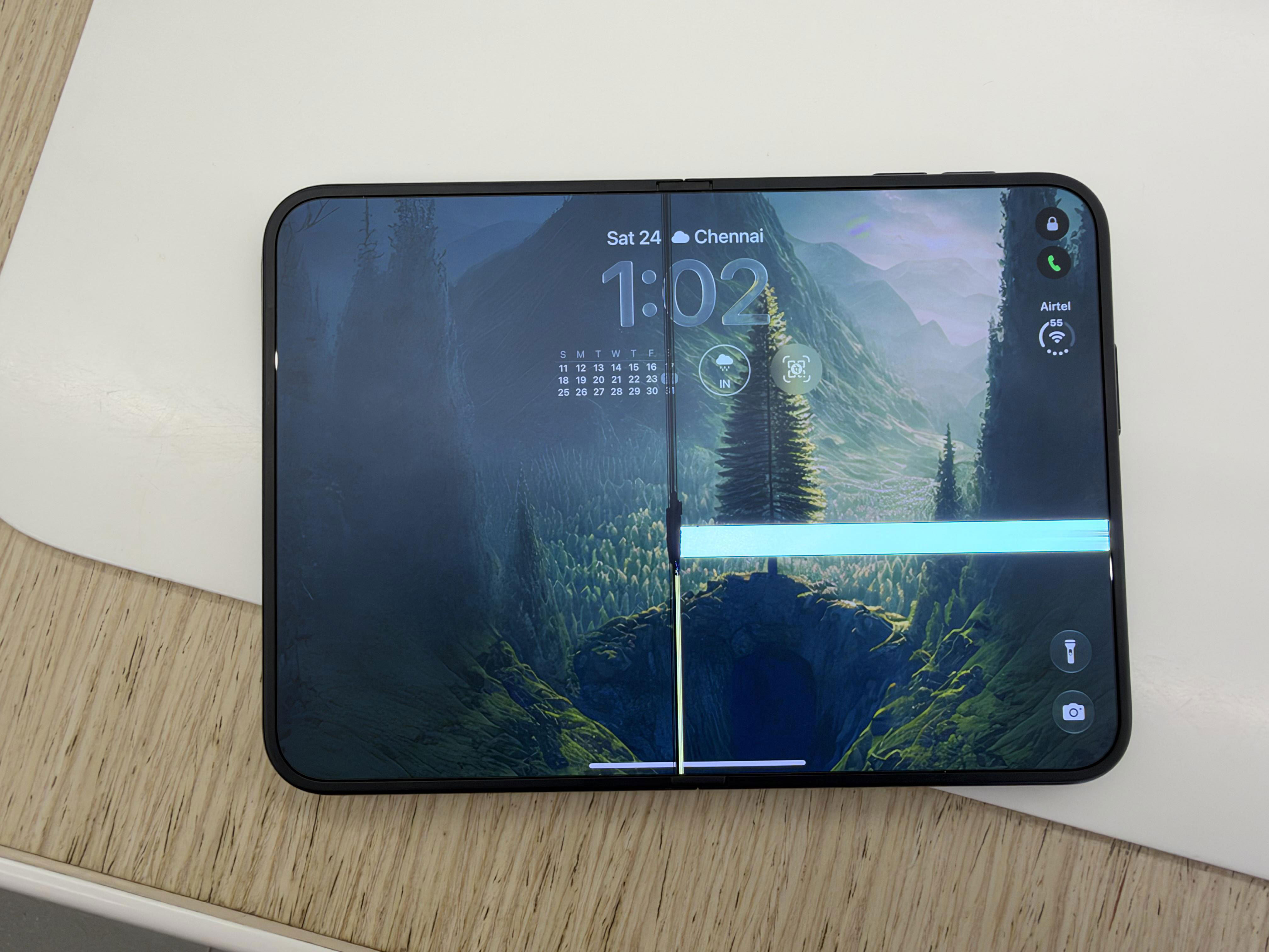 An iPhone Duo, unfolded, with a bright white line shot across the screen.