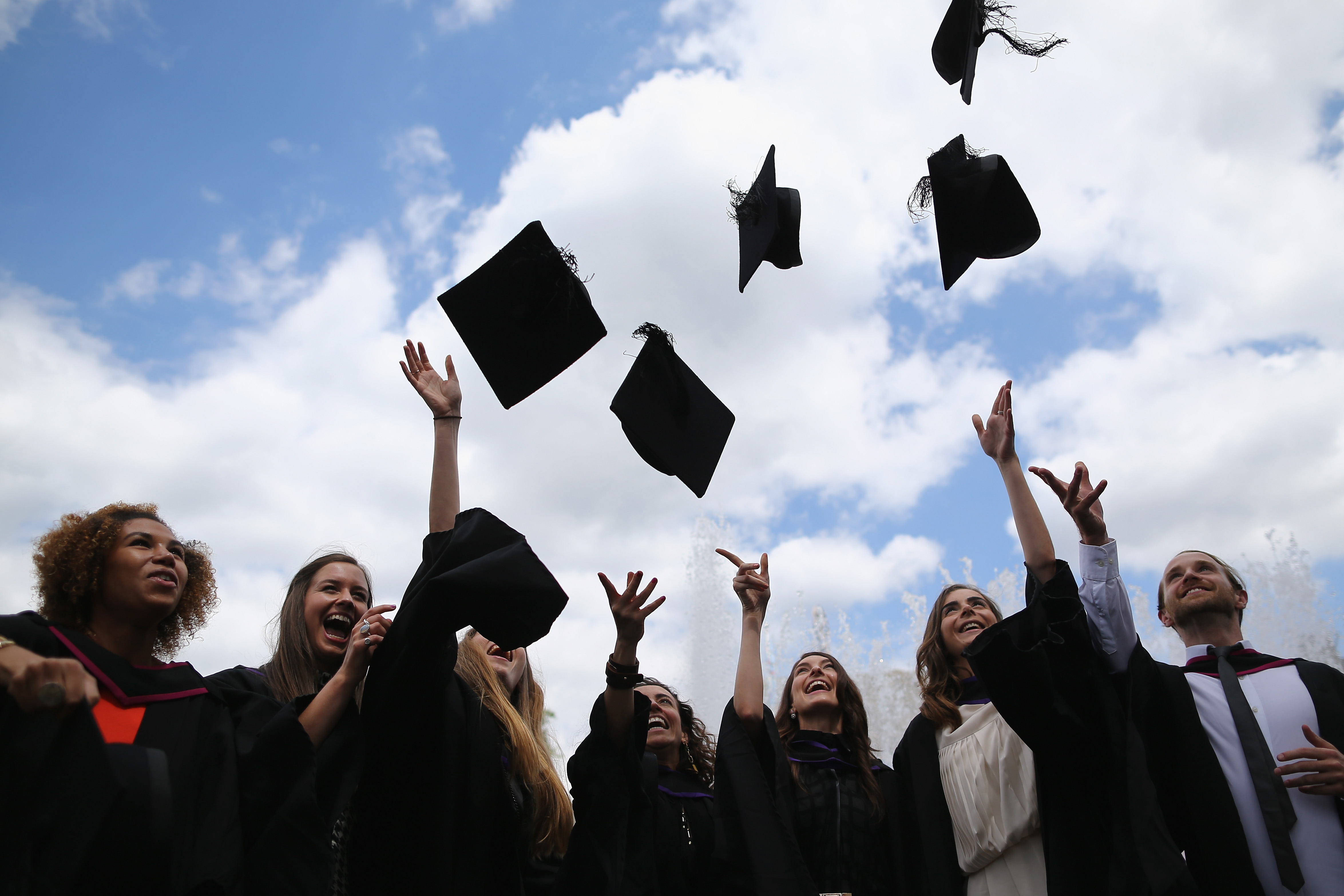 Graduates throw up their caps.