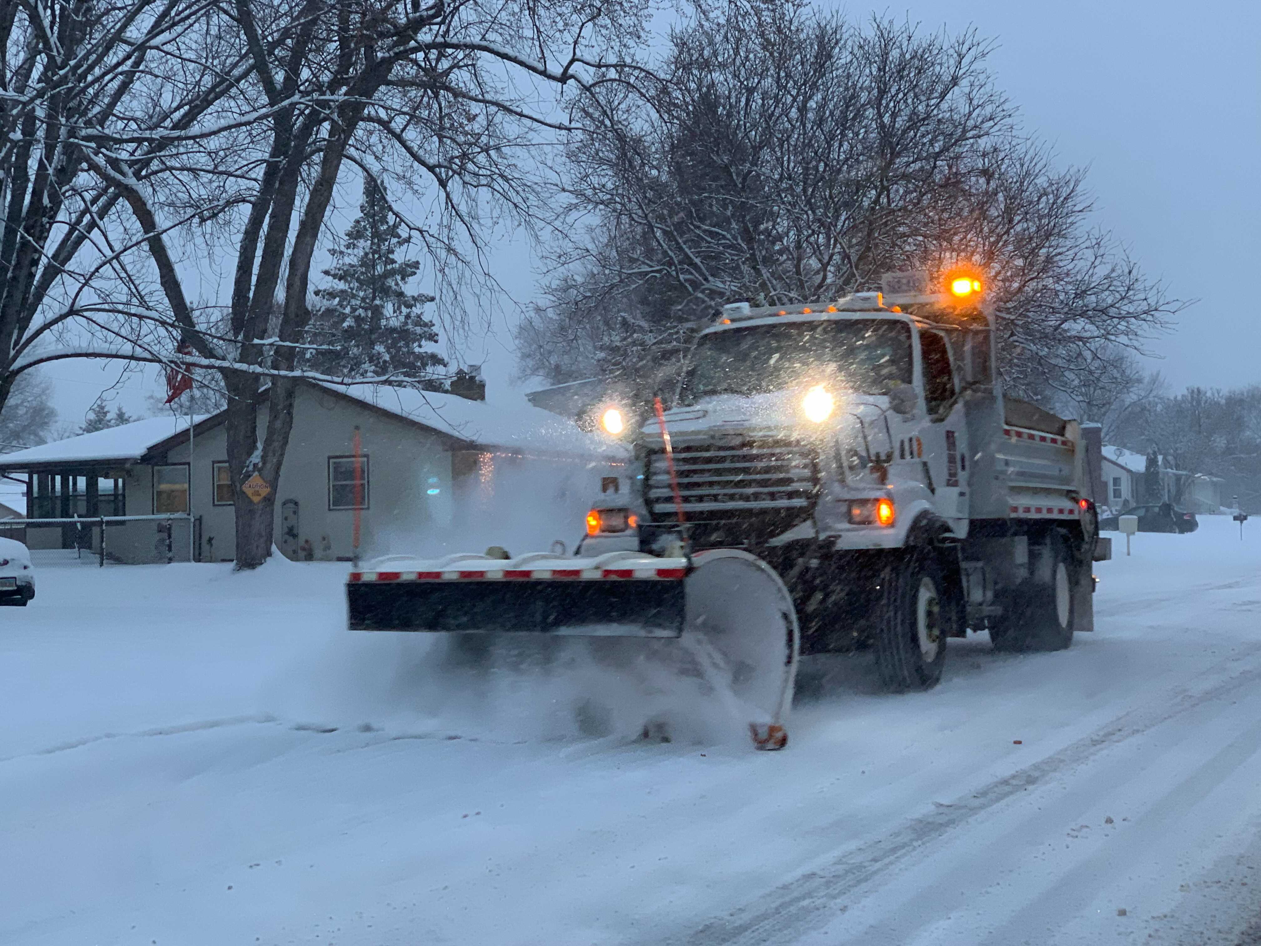 a snowplow clears a street.